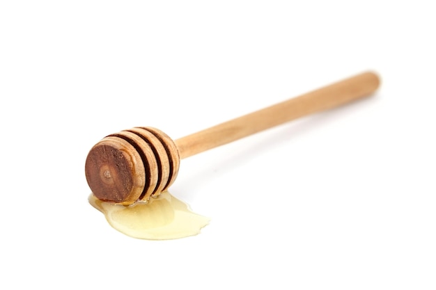 Palo de miel de madera con gota aislado en blanco