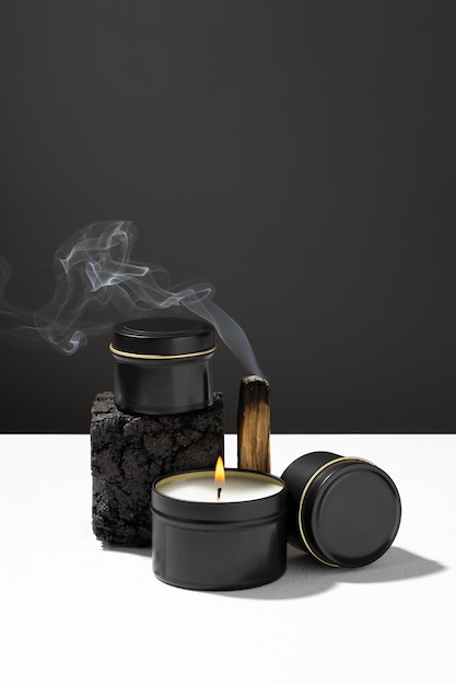 Foto palo santo ardente e velas de aroma feitas de cera de soja em um fundo preto relaxam zen