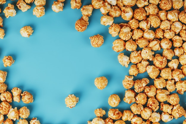 Palomitas de caramelo por una ondulación sobre un fondo azul, en forma de marco.