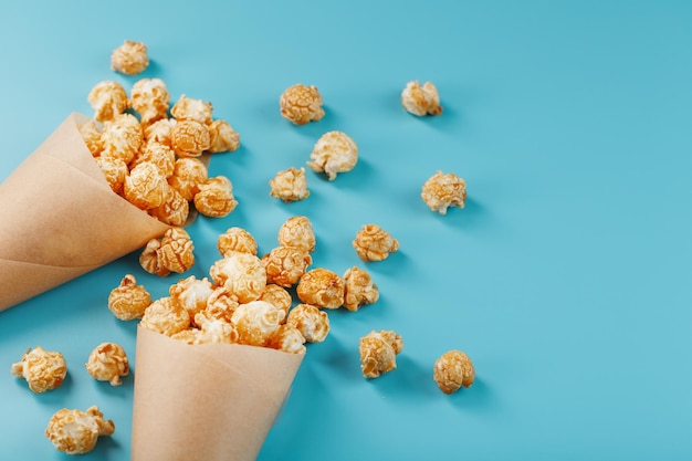 Palomitas de caramelo en un sobre de papel sobre un fondo azul.