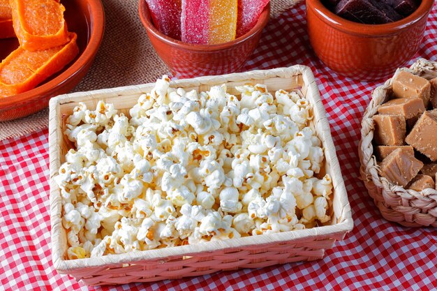 Foto palomitas de maíz en la canasta en la mesa de la fiesta dulce tradicional de las fiestas del país brasileño