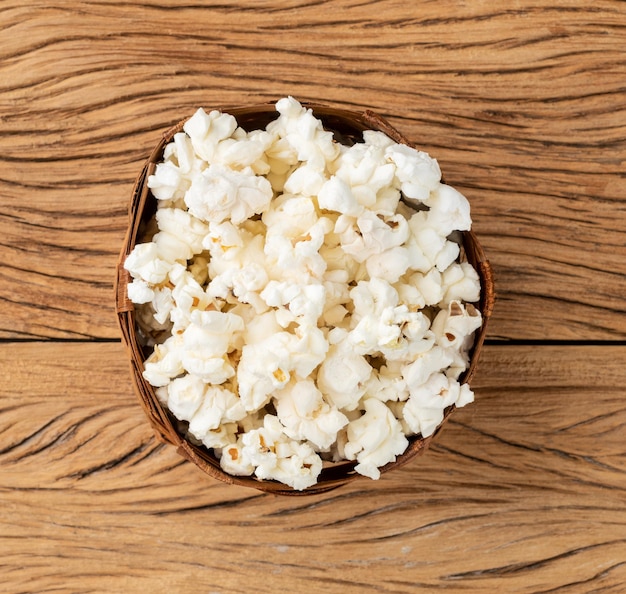 Palomitas de maíz en una canasta sobre mesa de madera