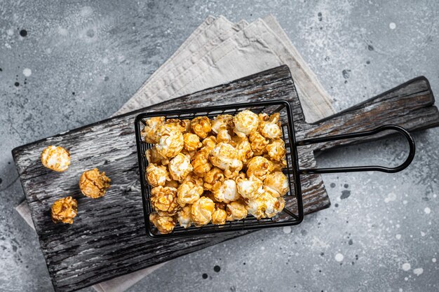 Palomitas de maíz con caramelo en cesta Fondo gris Vista superior