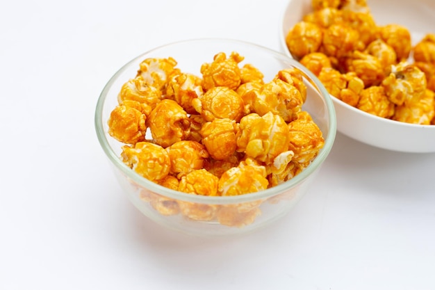 Palomitas de maíz con caramelo de miel sobre fondo blanco.