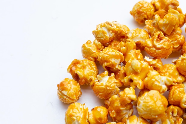 Palomitas de maíz con caramelo de miel sobre fondo blanco.