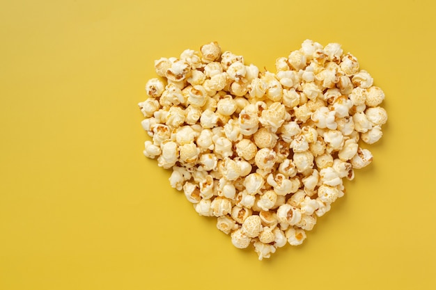 Palomitas de maíz dulce sobre fondo amarillo