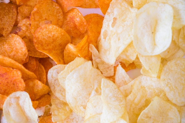 Palomitas de maíz fritas y patatas fritas en el fondo blanco.