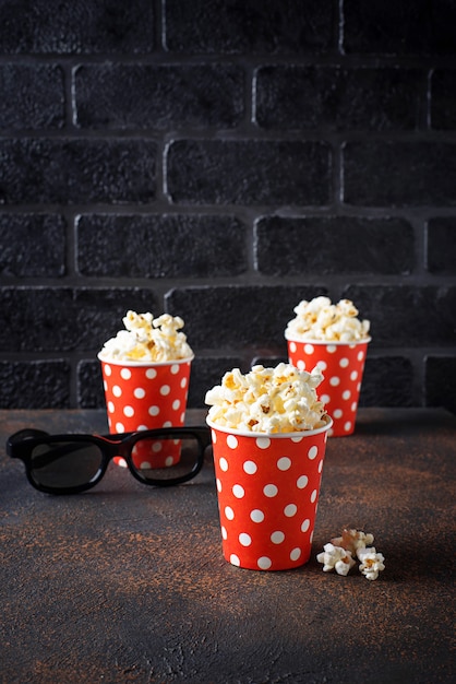 Palomitas de maíz con gafas 3d sobre fondo oscuro