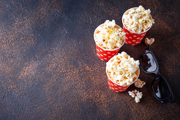 Palomitas de maíz con gafas 3d sobre fondo oscuro