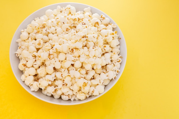 Palomitas de maíz con mantequilla en una taza de palomitas de maíz rojo, merienda en la casa o en el cine