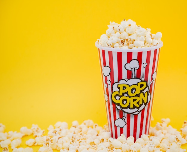 Palomitas de maíz con mantequilla en una taza de palomitas de maíz rojo, merienda en la casa o en el cine