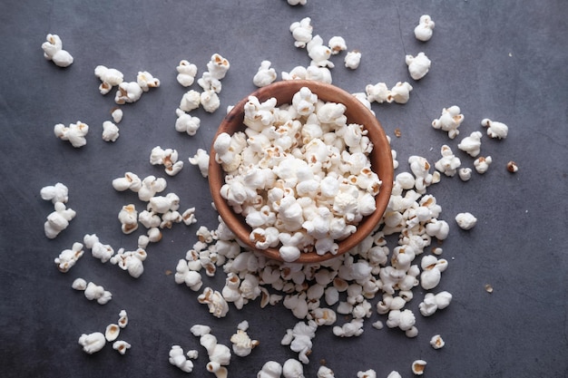 Palomitas de maíz en un recipiente sobre un escritorio de madera