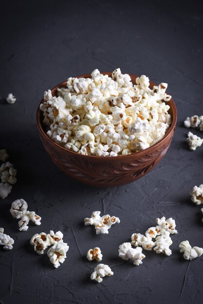 Palomitas de maíz saladas en un recipiente con gafas 3D sobre una mesa sobre una superficie gris. Vista superior.