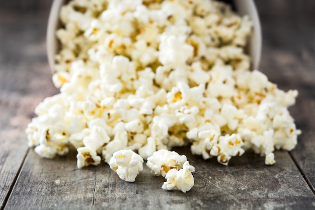 Palomitas de maíz en un tazón en la mesa de madera.