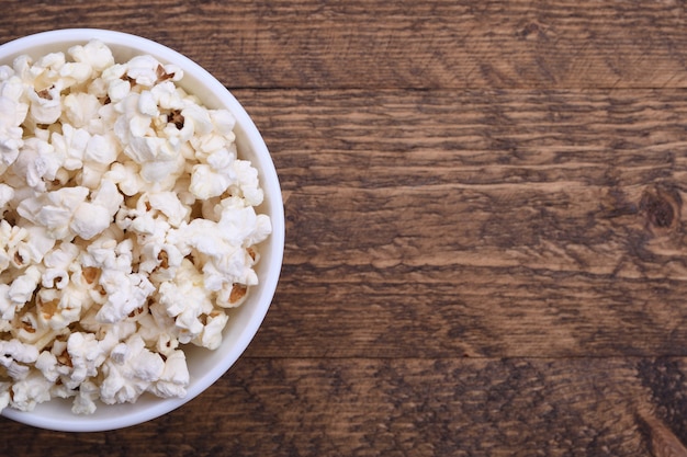 Palomitas de maíz en un tazón sobre una superficie roja