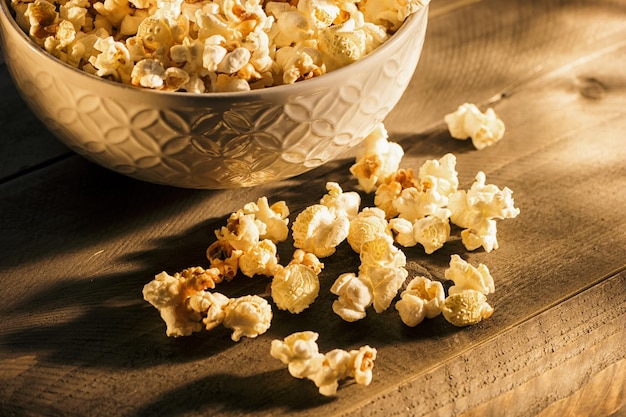 Palomitas de sal en un bol sobre la mesa de madera