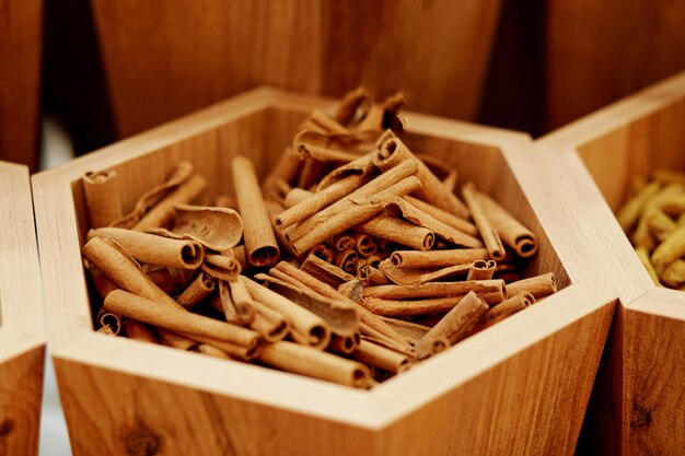 Palos de canela secos aromáticos en el fondo de la caja de madera Vista superior Foto de alta calidad