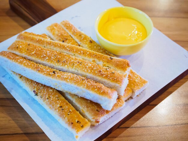 Palos de pan con salsa en la mesa de madera