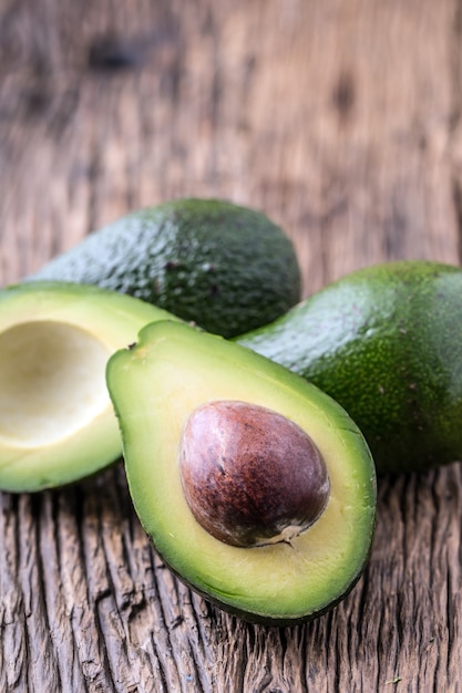 Palta. Cortar el aguacate en una mesa de fondo de madera de roble. Enfoque selectivo.