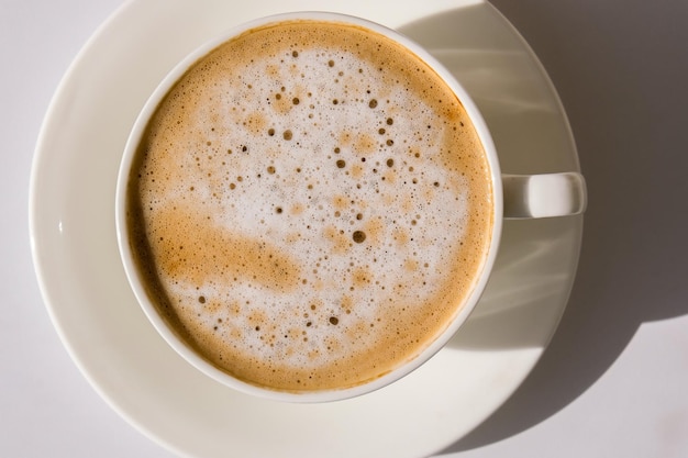 Foto pampas gras und weiße tasse mit kaffee trinken cappuccino im frühstück morgen zu hause