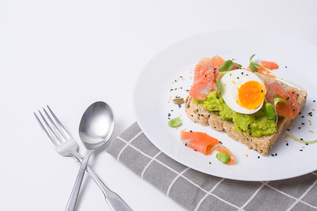 Pan con aguacate verduras fruta y huevo sobre fondo blanco Concepto de desayuno saludable