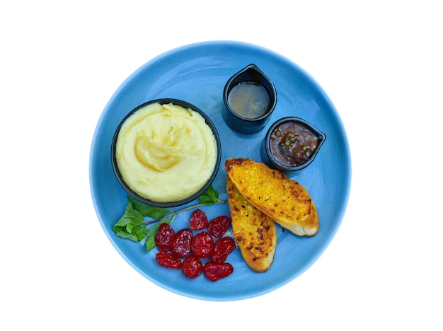 Pan de ajo y puré de patata en un plato sobre fondo blanco.