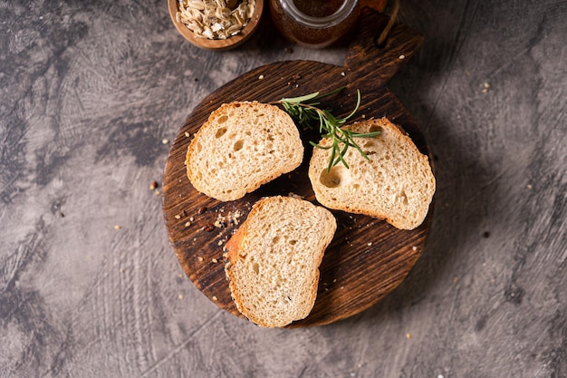 Pan artesanal de trigo entero baguete leche blanca y miel en tabla de madera rústica y mesa abstracta S