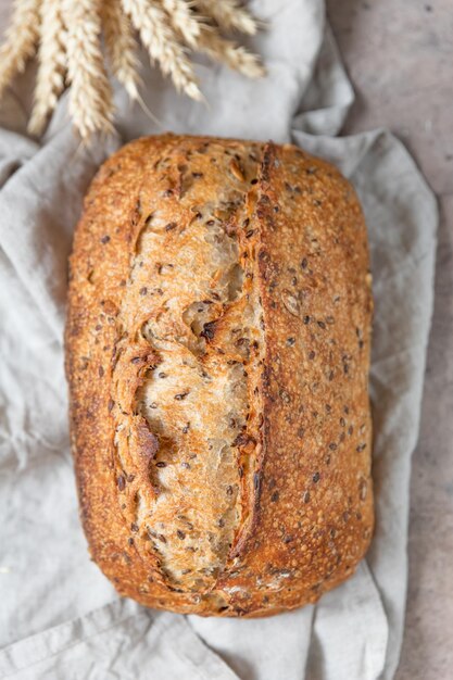 Pan artesano de masa madre con espigas y servilleta de lino Tartine con semillas multicereales