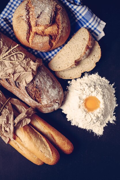 Pan y baguette envueltos en un papel listo para los clientes y un poco de harina con un huevo.