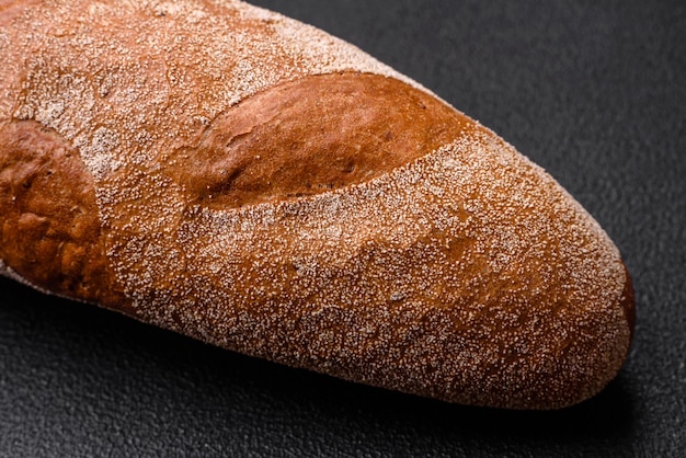 Pan de baguette francés sobre un fondo de hormigón de textura oscura haciendo deliciosa bruschetta en casa