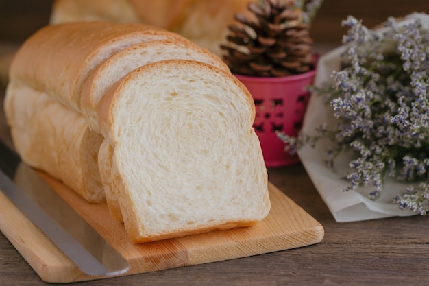 Pan blanco delicioso suave y pegajoso rebanado hecho en casa en la tabla de cortar de madera