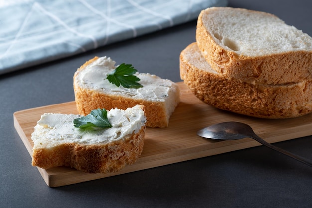 Pan blanco en el plato con requesón y hierbas Decorado con hierbas verdes Alimentos saludables