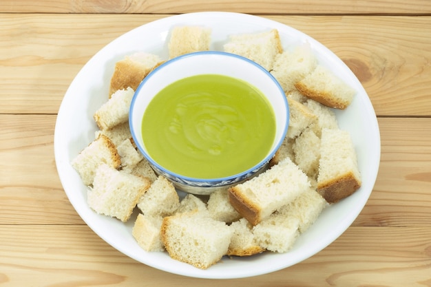 Pan casero al vapor y natillas pandan en placa de cerámica blanca sobre fondo de madera. Postre tailandés.