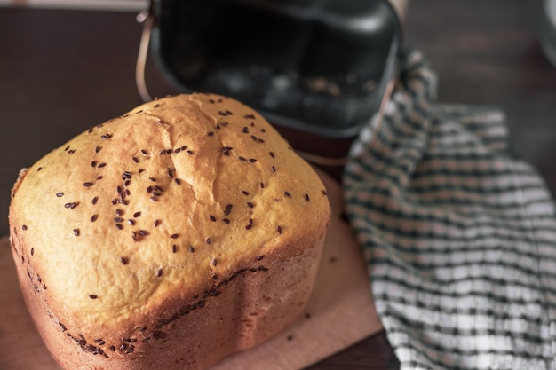 Pan casero fresco espolvoreado con lino y semillas de sésamo horneado en una máquina de pan Deliciosos pasteles caseros
