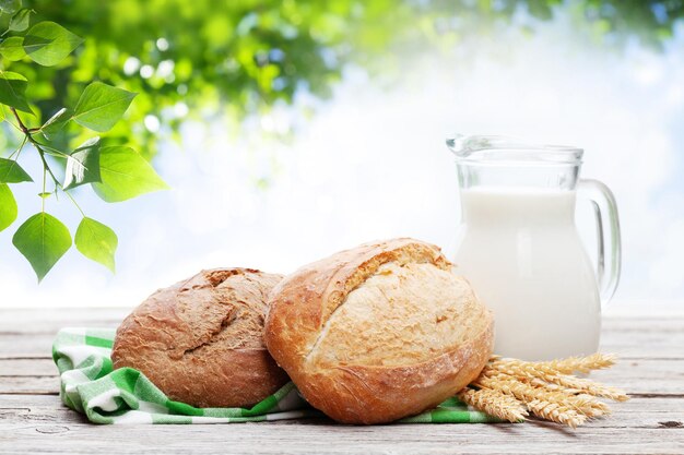 Pan casero y leche en mesa de madera