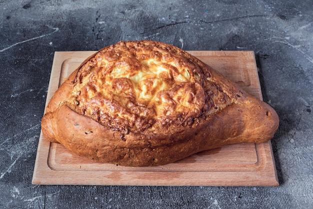 Pan casero con queso y ajo en una tabla de madera