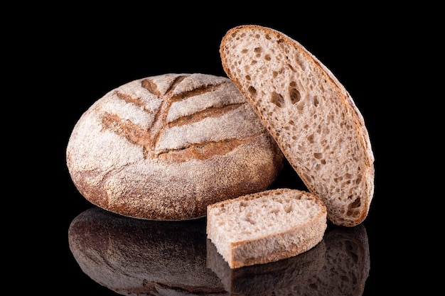 Pan casero recién horneado aislado en negro. Pan de centeno fresco. Alimentación saludable y panadería tradicional, concepto de pan para hornear.