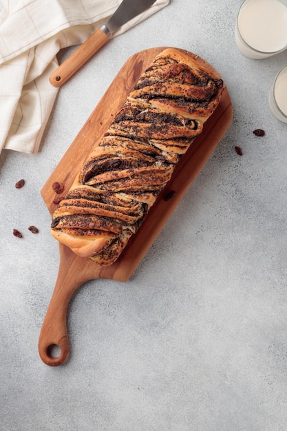 Pan casero de remolino dulce con semillas de amapola sobre un fondo de hormigón gris