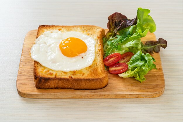 pan casero tostado con queso y huevo frito encima con ensalada de verduras para el desayuno