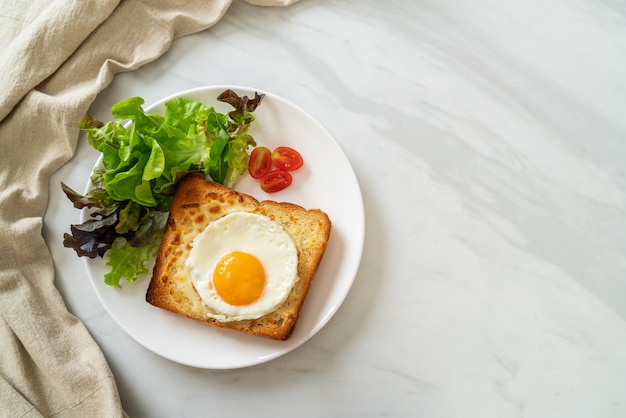 pan casero tostado con queso y huevo frito encima con ensalada de verduras para el desayuno