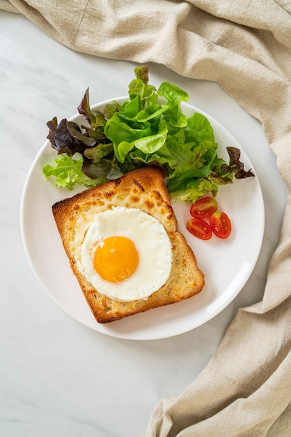 pan casero tostado con queso y huevo frito encima con ensalada de verduras para el desayuno