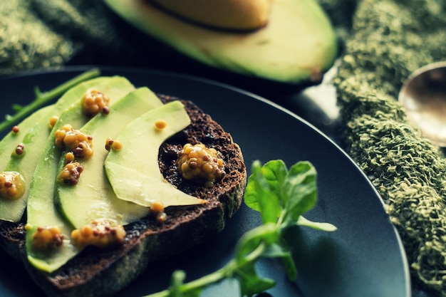 Pan de centeno con aguacate y semillas de mostaza. Concepto de desayuno de alimentos saludables