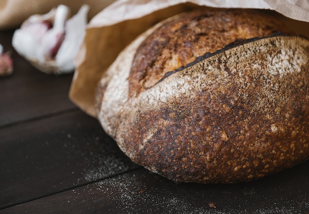 Pan de centeno caliente en círculo sobre una mesa de madera en paquete artesanal panadería de masa fermentada casera selectiva ...