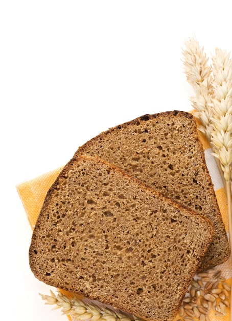 Pan de centeno y espigas de trigo aislado sobre fondo blanco.