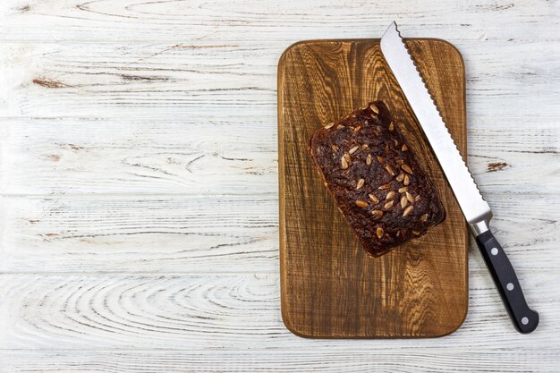 Pan de centeno fresco en la receta francesa en tabla de cortar con cuchillo