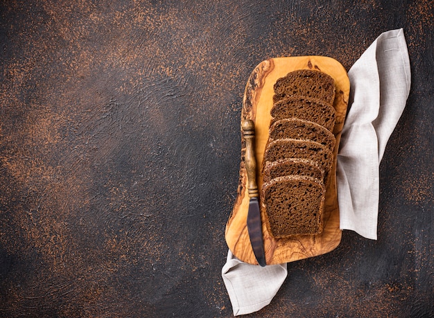 Pan de centeno fresco en rodajas sobre fondo oxidado