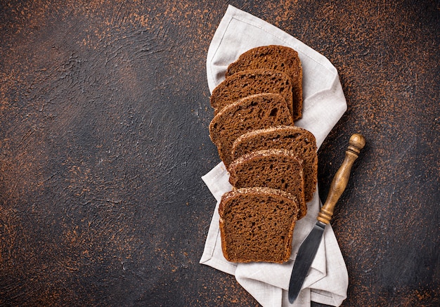 Pan de centeno fresco en rodajas sobre fondo oxidado