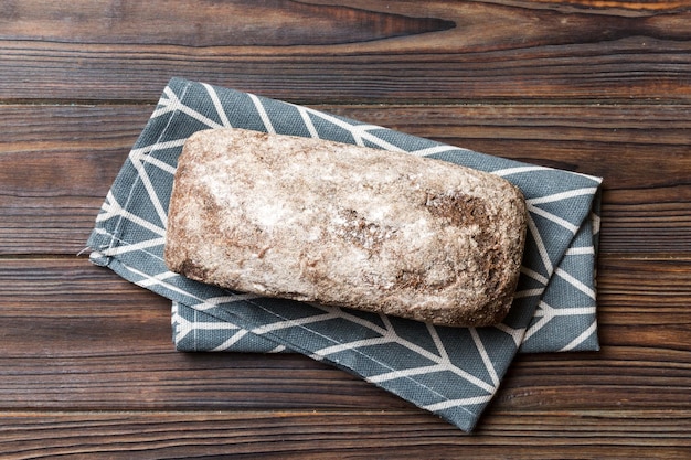 Pan de centeno fresco en una servilleta sobre fondo rústico vista superior de pan fresco