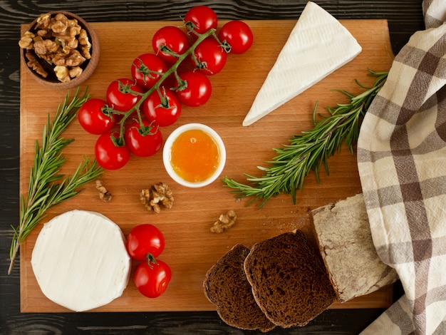 Pan de centeno con queso brie y camembert, nueces, miel, tomates cherry y romero.