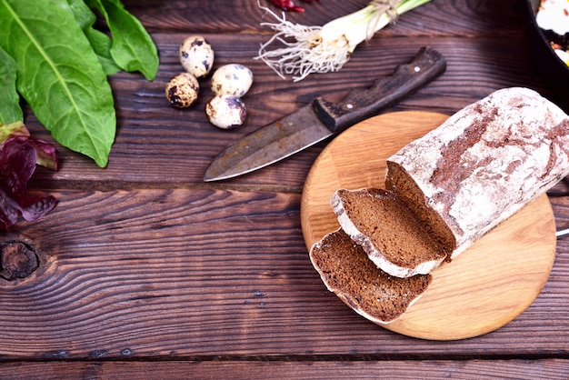 Pan de centeno rebanado en un tablero de cocina de superficie de madera